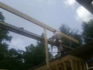 Carpenter setting a ridge beam over a new addition frame — Ice Dam Removal by Roofing Brothers in Lake Waccamaw
