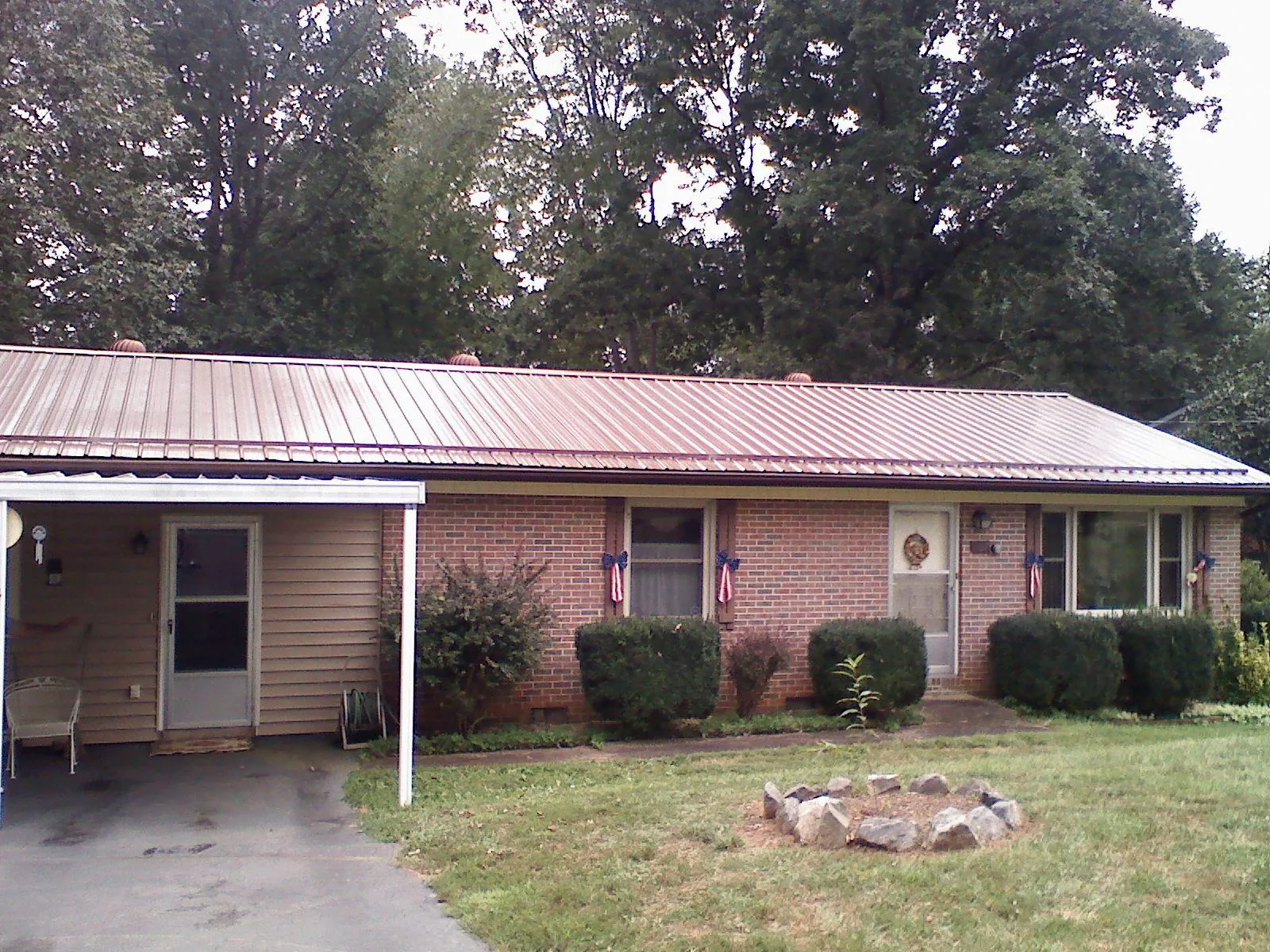 Bronze metal roof and carport on a brick ranch home — Roof Repair work by our crew in Lake Waccamaw
