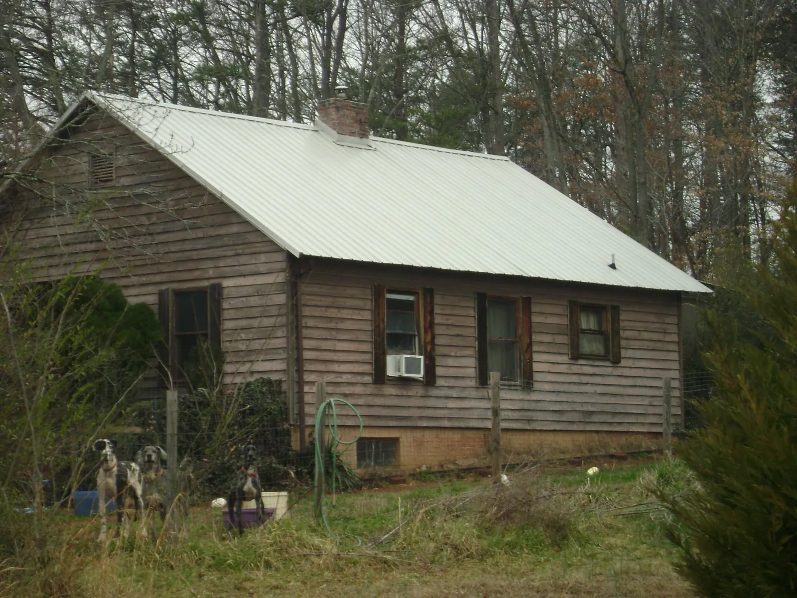 White metal roof on an old wood sided farmhouse, from a Metal Roof Installation job in Lake Waccamaw